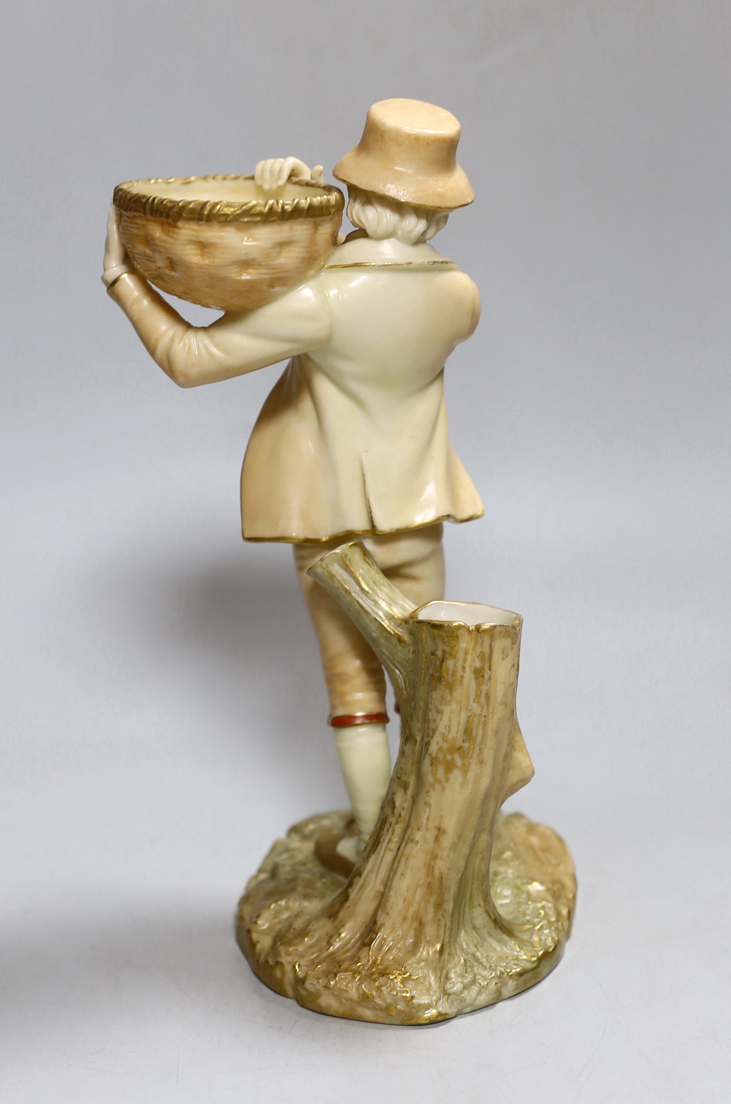 A Royal Worcester figure of a boy, highlighted in gold, with a wicker basket in his hands, painted in blush ivory, shape 880, date mark 1899, 24cm high